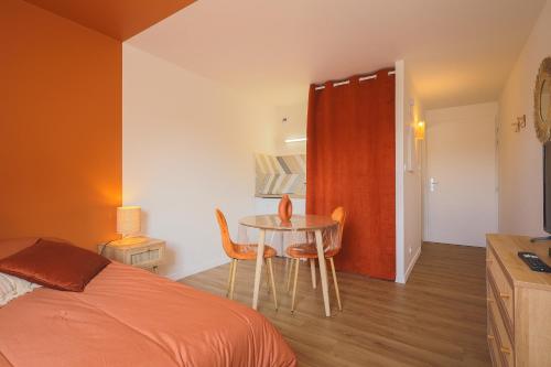 une chambre avec un lit, une table et des chaises dans l'établissement Charmant Studio bohème en centre ville, à Saint-Brieuc