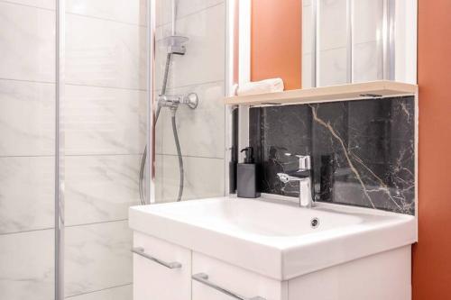 W łazience znajduje się biała umywalka i prysznic. w obiekcie Charmant 2 pièces, 2 couchages séjour glamour w Amiens