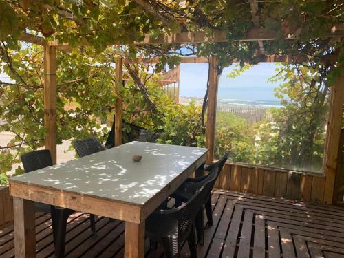 a table and chairs on a deck with a view at Portofino Surf Camp in Ciudad de Chañaral