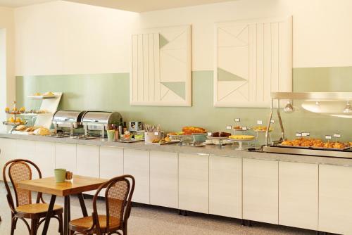 uma cozinha com mesa e um balcão com comida em Lime Hotel em Rimini