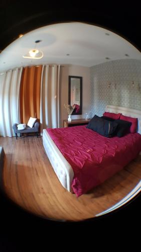 a bedroom with a large bed with a red blanket at Une Parenthese in Floirac