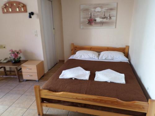 a bedroom with a bed with two pillows on it at Tina Hotel in Chania Town
