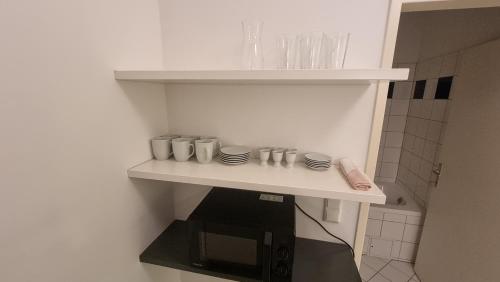 estante en una cocina con microondas en Sunny Apartment next to Metro 1BR, en Viena