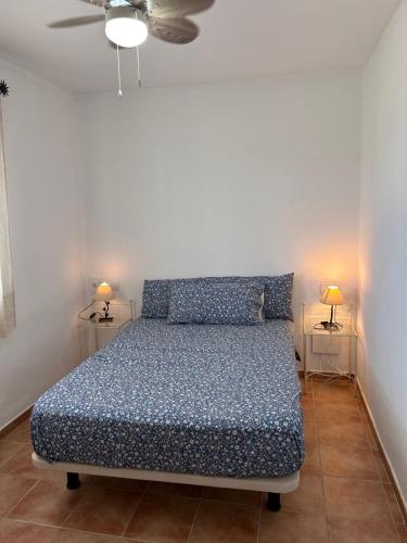 ein Schlafzimmer mit einem Bett und zwei Tischen mit Lampen in der Unterkunft Finca rústica “Puerta Palo” in Alozaina