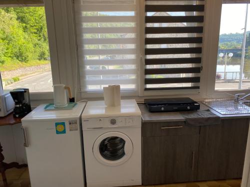 a kitchen with a washing machine and a window at La casa du port, Chambres, suite privée, appartement avec vue sur la rivière in Capdenac
