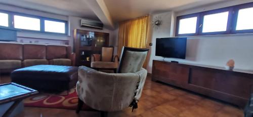 a living room with a flat screen tv and chairs at Angel's House in Bianco