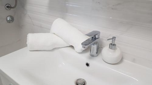 La salle de bains est pourvue d'un lavabo et de serviettes en papier. dans l'établissement Apartman Nagy, à Dramalj