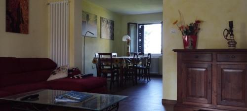 a living room with a red couch and a table at La Quagnola splendida casa in Appennino in Polinago