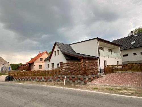 a house on the side of a street with a fence at Chalupa Vlasta in Kadov