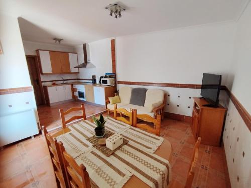 a living room with a table and a kitchen at Retiro del Bullaque in El Robledo