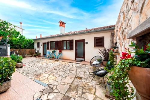 a house with a stone courtyard with two chairs at Villa B&B Marina & Parking Free in Rovinj