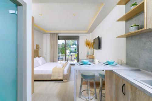 Habitación con cama y cocina con mesa en Yasemi Luxury Rooms en Limenas