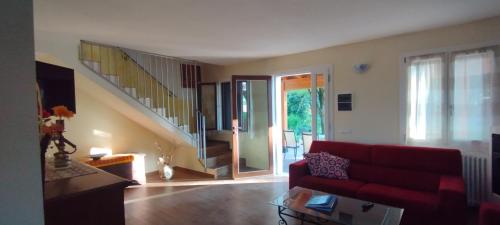 a living room with a red couch and a staircase at La Quagnola Casa vacanze in Polinago