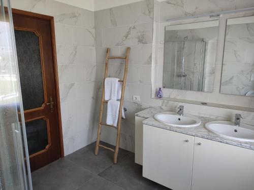 a bathroom with two sinks and a mirror and a ladder at Villa Lidia, Como Lake in Colico