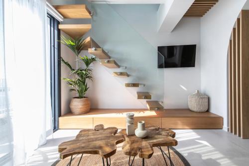 a living room with a wooden table and stairs at Nōema Premium Stay in Neos Marmaras