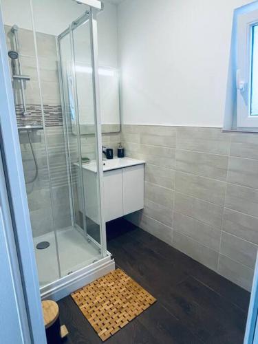 une salle de bain avec une douche en verre et un lavabo dans l'établissement Appartement NEUF chaleureux - Comme à la maison, à Limoges