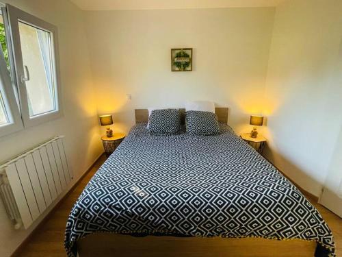 une chambre avec un grand lit avec deux lampes dans l'établissement Appartement NEUF chaleureux - Comme à la maison, à Limoges
