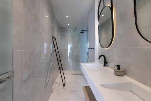 a bathroom with two sinks and a shower at Nōema Premium Stay in Neos Marmaras