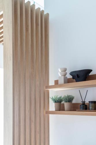 a wooden wall with some plants on a shelf at Nōema Premium Stay in Neos Marmaras