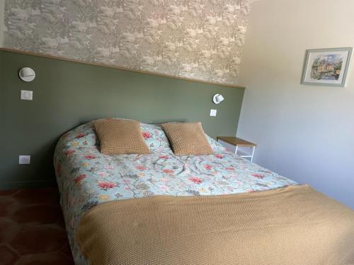 a bedroom with a bed with a floral bedspread at Gîte au bord du Cher "La Mésange Verte" in Savonnières