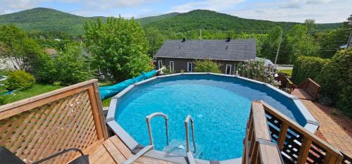 a large blue pool with a water slide at Superbe propriété moderne en nature in Sainte Brigitte de Laval