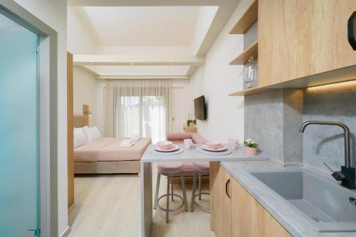 een keuken met een wastafel en een kamer met een bed bij Yasemi Luxury Rooms in Limenas