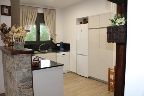 uma cozinha com armários brancos e uma bancada em El racó del Puig em Banyoles