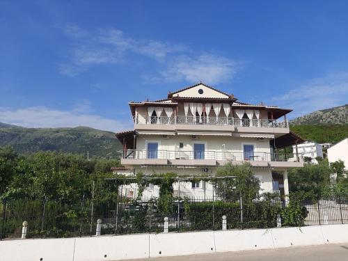 un edificio con balcón en la parte superior de una valla en Rexhos Studios, en Himare