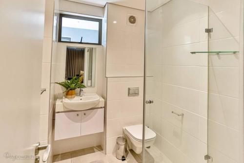 a bathroom with a toilet and a sink and a shower at Zimbali Lakes Boulevard Suite 134 in Sheffield Beach