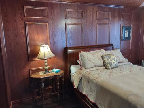 1 dormitorio con 1 cama y 1 mesa con lámpara en The King George Inn en Cobourg