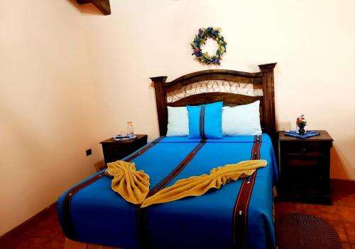 una camera con letto blu e testiera in legno di Hotel Casa Sofia a Antigua Guatemala