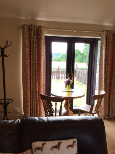 a living room with a couch and a table and a window at Sycamore, Moss Hagg Farm in Selby