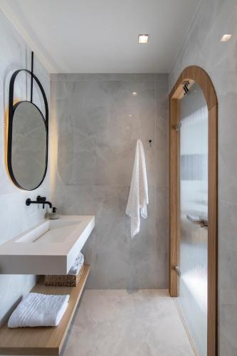 a bathroom with a sink and a mirror at Nōema Premium Stay in Neos Marmaras