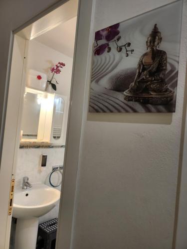 a bathroom with a sink and a picture of a woman at Housenovoli in Florence
