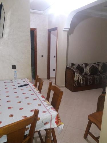 a dining room with a table and a bed at Appartement Sidi-Bouzid in Sidi Bouzid