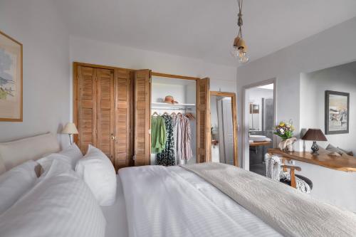 a bedroom with a bed with white sheets and a mirror at Sakali Mansion in Pinakátai
