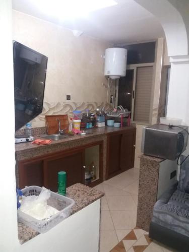 a kitchen with a counter with a sink and a tv at Appartement Sidi-Bouzid in Sidi Bouzid