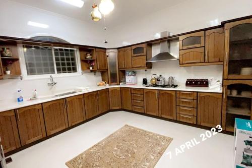 a large kitchen with wooden cabinets and a rug at The luxury Home in Abha