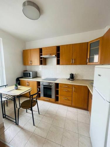 una cucina con armadi in legno, tavolo e frigorifero di CENTRAL STUDIO CLOSE TO ANDRASSY AVENUE for 4 persons a Budapest