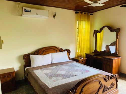 a bedroom with a wooden bed and a mirror at Florence Residence Makola in Kadawatha