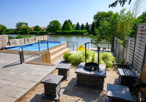 a backyard with a swimming pool and a fire pit at Körös-parti Terasz Vendégház in Békésszentandrás