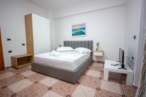 a bedroom with a bed and a television in it at Vila Era Ksamil in Ksamil