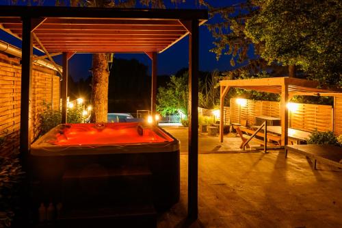 a hot tub in a backyard at night at Körös-parti Terasz Vendégház in Békésszentandrás