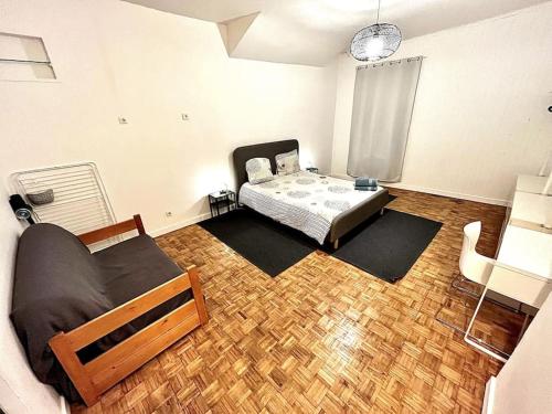 een slaapkamer met een bed en een houten vloer bij Grenoble Hypercentre - Appartement vieille ville - Wifi in Grenoble