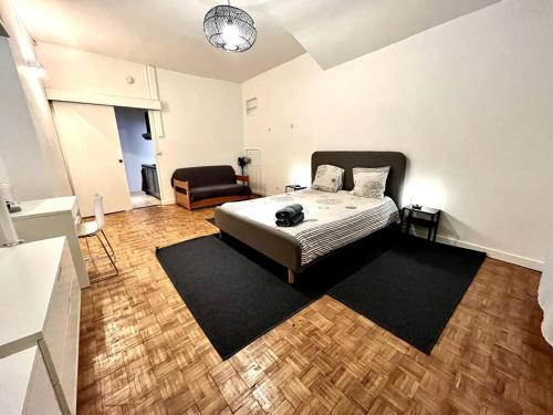 een slaapkamer met een bed en een stoel erin bij Grenoble Hypercentre - Appartement vieille ville - Wifi in Grenoble