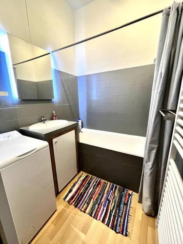 La salle de bains est pourvue d'un lavabo, d'une baignoire et d'un tapis. dans l'établissement Grenoble Hypercentre - Appartement vieille ville - Wifi, à Grenoble
