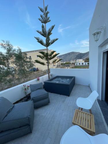 a patio with a couch and a tree on a balcony at Sun Springs Suites in Kamari