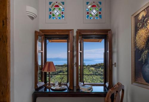 a room with two windows and a table with a lamp at Sakali Mansion in Pinakátai