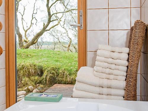 a stack of towels in a bathroom with a window at Sithean in Taynuilt