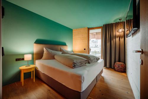 sypialnia z łóżkiem i zieloną ścianą w obiekcie Appartement Schwarz w mieście Sankt Johann im Pongau